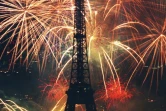 Après un Nouvel An 2016 a minima dans la foulée des attentats du 13 novembre, Paris est de nouveau une fête: un demi-million de personnes sont attendues samedi soir sur les Champs-Elysées. Photo de la Tour Eiffel sous les feux d'artifice le 14 juillet 2000