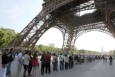 Des visiteurs en file d'attente sous la Tour Eiffel le 21 avril 2011 à Paris
