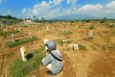 Un homme sur la tombe d'un proche dans un cimetière pour les victimes du Covid-19 à Semarang, en Indonésie, le 30 juin 2021