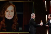 Le directeur artistique de la Berlinale Carlo Chatrian (d) remet au réalisateur français Laurent Lariviere l'Ours d'or d'honneur décerné à Isabelle Huppert en vidéoconférence  à Berlin le 15 février 2022