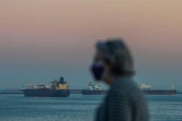 Une promeneuse devant l'océan à Long Beach, alors que passent des pétroloiers au large, le 25 avril 2020