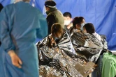 Des personnes enveloppées dans des couvertures de survie à l'extérieur du centre médical Caritas, le 16 février 2022 à Hong Kong