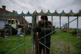 Vassili Kouchtch ferme la grille de la ferme où il travaille à Mala Tokmachka, le 23 avril 2022 en Ukraine