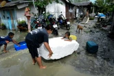 Des enfants jouent dans une rue inondée après le passage de la tempête Pabuk dans le sud de la Thaïlande, le 5 janvier 2019