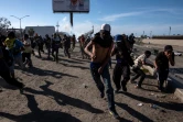 Des migrants centraméricains s'enfuient après des tirs de gaz lacrymogène par les forces de l'ordre américaines, près de la frontière entre le Mexique et les Etats-Unis à Tijuana, le 25 novembre 2018
