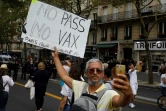 Un homme prend un selfie en tenant une pancarte lors d'une manifestation contre la vaccination obligatoire contre le Covid-19 pour certains travailleurs à Paris le 21 août 2021