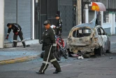 Des policiers inspectent l'épave d'un véhicule après l'explosion de deux voitures piégées à Quito, le 31 août 2023 en Equateur