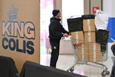 Des acheteurs lors d'une "vente à l'aveugle" de colis non réclamés, où les boîtes de toutes tailles sont vendues au poids dans un centre commercial de Rome, le 17 janvier 2025 