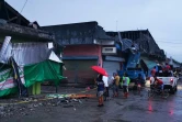 Des habitants devant des bâtimments détruits par un puissant séisme, à Padada dans la province de Davao del Sur sur l'île de Mindanao aux Philippines le 15 décembre 2019