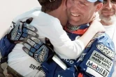 le pilote français Stéphane Peterhansel (Yamaha), vainqueur du 20e rallye-raid Paris-Dakar dans la catégorie motos, embrasse son fils Nicolas, le 18 janvier 1998 à Dakar, à l'issue de la 17e et dernière étape, disputée entre Saint-Louis et Dakar 