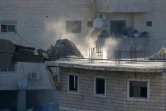 Photo prise le 22 juillet 2019 depuis la Cisjordanie occupée montrant les forces israéliennes s'apprêtant à démolir un immeuble palestinien inachevé à Wadi al-Hummus dans le secteur palestinien de Sour Baher, dans la région de Jérusalem