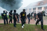 Des membres du collectif des "500 frères" fuient des tirs de gaz lacrymogène lors d'une manifestation devant la préfecture de Cayenne, le 7 avril 2017 en Guyane