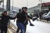 Des Palestiniens portent un blessé après une opération de l'armée israélienne dans le camp de réfugiés de Nour Chams, près de la ville de Tulkarem, dans le nord de la Cisjordanie, le 10 avril 2022