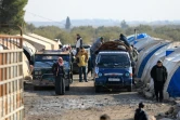 Des déplacés syriens vident leurs tentes et chargent leurs affaires sur des camions pour emménager dans un complexe résidentiel, construit près de la ville d'al-Bab, le 9 février 2022 en Syrie 