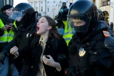 Des policiers arrêtent une jeune manifestante protestant contre l'invasion de l'Ukraine par les troupes russes, le 13 mars 2022 à Saint-Pétersbourg, en Russie