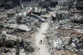 Photo d'archive d'un homme poussant un vélo au milieu des décombres dans la ville de Gaza, le 3 avril 2024