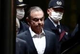 Carlos Ghosn, escorté par des policiers, quitte le centre de détention après sa libération sous caution, le 25 avril 2019 à Tokyo