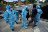 Des proches revêtus de combinaisons de protection portent le corps d'une victime du coronavirus lors de funérailles à Srinagar, Inde, le 7 mai 2021