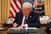 Le président américain Donald Trump signe des décrets dans le Bureau ovale de la Maison Blanche, le 20 janvier 2025 à Washington