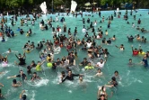 Des hommes se rafraichissent dans une piscine, par une chaude journée d'été, le 28 avril 2022 à Lahore, au Pakistan