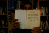 Mosaab Abou Toha (G) montre un exemplaire d'un livre envoyé par le philosophe américain Noam Chomsky dans sa maison de Beit Lahya dans le nord de Gaza le 20 février 2017