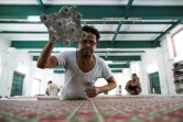 Un employé travaille sur une pièce d'étoffe imprimée à la planche dans l'atelier de la créatrice Brigitte Singh, le 2 juin 2022 à Amber, dans l'Etat du Rajasthan, en Inde