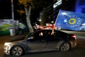 Des partisans du parti au pouvoir, le Rêve géorgien, brandissent des drapeaux après des sondages annonçant sa victoire aux élections législatives, a Tbilissi le 26 octobre 2024
