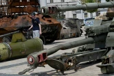 Cycliste parmi les chars russes détruits exposés dans le centre de Kiev, le 29 juin 2022