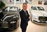 Le directeur général de Rolls-Royce, Torsten Müller-Ötvös pose entre un modèle de Rolls-Royce Dawn (g) un modèle Wraith Black Badge (d) dans le showroom du centre de Londres le 9 janvier 2019 2019
