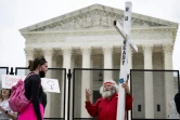 Un opposant au droit à l'avortement et une militante pro-choix face à face devant la Cour suprême des Etats-Unis, le 5 mai 2022 à Washington 
