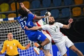 L'arrière gauche français, Jean-Jacques Acquevillo, tente de tirer au but malgré la défense algériennes, lors de leur match du Mondial de handball, le 20 janvier 2021 dans la Ville du 6 Octobre, un faubourg proche du Caire