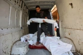 Un Palestinien transporte le corps d’un enfant dans une camionnette contenant les dépouilles d'autres personnes tuées lors de frappes aériennes israéliennes, dans l’enceinte de l’hôpital Al-Ahli Arab de Gaza-Ville, le 21 mai 2025
