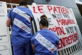 Des soignants des urgences de l'AP-HP attachent des banderoles à l'entrée de La Pitié-Salpêtrière à Paris, le 15 avril 2019, pour protester contre leurs conditions de travail. 