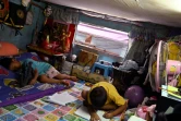 Les deux enfants de la famille Noidee dans l'unique pièce qu'ils habitent dans un bidonville de Bangkok, le 28 mai 2020 en Thaïlande