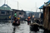 Des habitants se déplacent en pirogue, dans le bidonville flottant de Makoko, à Lagos, le 23 octobre 2019 au Nigeria