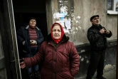 Des habitants sur le pas de porte de leur immeuble durant des bombardements sur la ville de Chtchastia, près de Lougansk, en Ukraine, le 22 février 2022