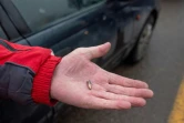 Un conducteur montre le 8 janvier 2022 dans une station de service d'Almaty, capitale du Kazakhstan, une balle qui a percuté sa voiture