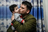 Hamid Safi, un chauffeur de taxi, embrasse Sohail Ahmadi qu'il avait trouvé à l'aéroport de Kaboul dans le chaos des évacuations en août 2021 et dont il a cherché la famille, chez le grand-père du garçon à Kaboul le 9 janvier 2022