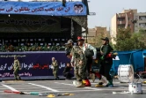 Des soldats portent un camarade blessé lors d'un attentat contre une parade militaire, le 22 septembre 2018 à Ahvaz, en Iran