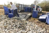 Shannon Batte vide des poubelles remplies de coquilles d'huîtres sur un "site de cure", avant d'être recyclées en récif, le 21 décembre 2020 à Pasadena, au Texas