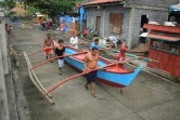 Des habitants de Legaspi City, province d'Albay, au sud de Manille, mettent une embarcation à l'abri avant l'arrivée du typhon Kammuri