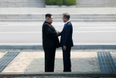 Le président sud-coréen Moon Jae-in (d) et le leader nord-coréen Kim Jong Un se serrent la main, le 27 avril 2018 à Panmumjom, dans la Zone démilitarisée séparant les deux Corées