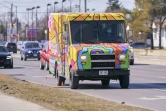 L'un des 37 camions de livraison de la Poste canadienne repeints de couleurs vives pour apporter un peu de gaieté pendant la pandémie, circule dans une rue de London (Ontario) le 12 mars 2021
