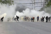 Des manifestants anti-coup d'Etat en Birmanie fuient les gaz lacrymogènes tirés par les forces de l'ordre, à Mandalay le 15 mars 2021