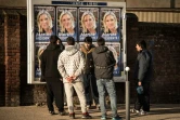 Des migrants regardent les panneaux électoraux à Calais avec en affiche la tête de liste FN de la région Nord, Marine Le Pen, le 7 décembre 2015