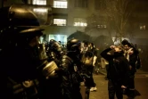 Un manifestant utilise du sérum physiologique pour atténuer les effets des gaz lacrymogènes alors qu'il fait face à la police anti-émeute lors d'une manifestation à Lyon, dans l'est de la France, le 20 mars 2023 ( AFP / JEFF PACHOUD )