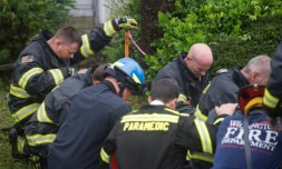 Des pompiers en opération prient sur les lieux où une femme et son enfant ont été tués par la chute d'un arbre lors du passage de l'ouragan Florence, le 14 septembre 2018 à Wilmington, en Caroline du Nord
