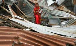Une jeune fille parmi les débris de sa maison le 28 mai 2024 à Patuakhali au Bangladesh aprÚs le passage du cyclone Remal