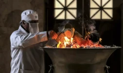 Un prêtre zoroastrien ajoute du bois au feu sacré dans le sanctuaire du temple du feu de Yazd, dans le centre de l'Iran, le 4 juillet 2023 ( AFP / ATTA KENARE )