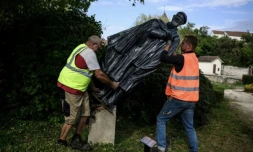 Des employés municipaux déboulonnent une statue de l'abbé Pierre, à Norges-la-Ville, le 17 septembre 2024 en Côte d'Or ( AFP / JEFF PACHOUD )